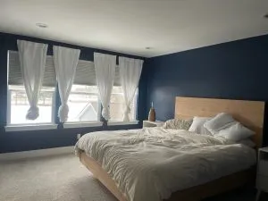Navy blue bedroom painting with white curtains Michigan