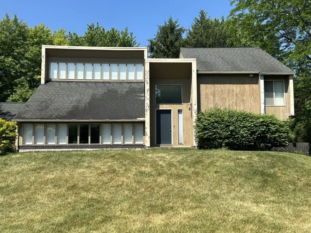 Weathered wood siding on modern Michigan home before exterior painting