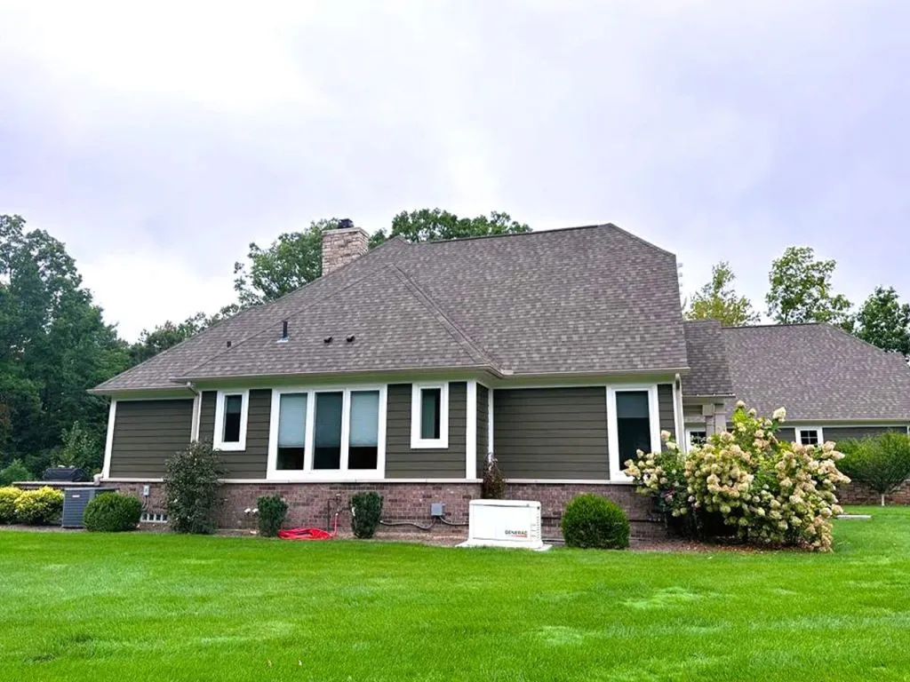 "Freshly painted gray house exterior with landscaped lawn"